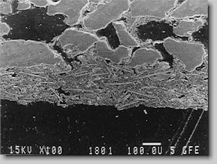 Bild 7. Anschliff eines geschlichteten Coldbox-Formstoffes, 80-fach